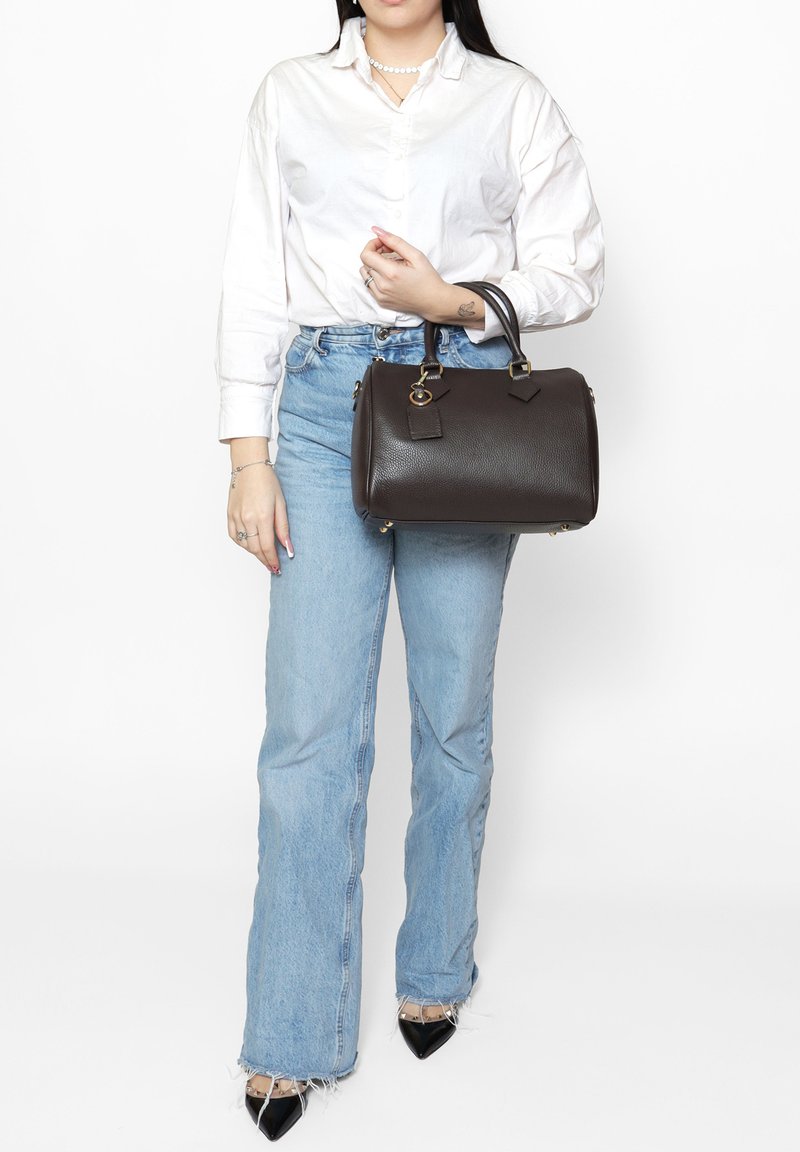 Borsa a mano in pelle marrone con superficie testurizzata, forma arrotondata, manici corti, dettagli in metallo dorato e un'etichetta removibile.