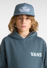 Gorra azul con el logotipo "VANS OFF THE WALL" bordado en blanco. Sudadera gris con "VANS" impreso en blanco en la parte frontal.