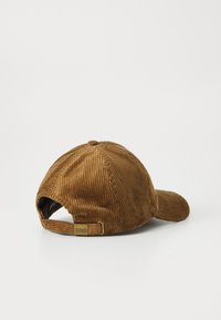 Bordeaux corduroy baseballcap met verstelbare band en messing gesp gemarkeerd met "Barbour," van achteren getoond op een witte achtergrond.