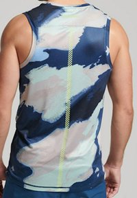 Débardeur de sport sans manches, présentant un motif abstrait bleu et crème, avec un tissu texturé et une bande réfléchissante jaune accentuée au centre.