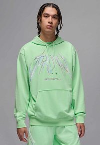 Felpa leggera verde con la scritta "JORDAN" in lettere iridescenti, cappuccio con coulisse e tasca a marsupio anteriore, abbinata a pantaloni corti coordinati.