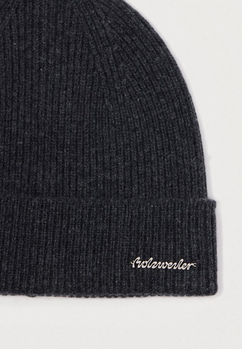 Dunkelgraue Strickmütze mit Rippstruktur. Verfügt über einen umgeschlagenen Rand und ein gesticktes "Wolverine"-Logo in einer kontrastierenden Farbe.