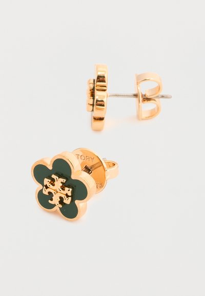 Σκουλαρίκια καρφάκια σε χρυσή απόχρωση, σε σχήμα τετράφυλλων τριφυλλιών με σκούρα πράσινα ένθετα και κεντρική λεπτομέρεια με χρυσό λογότυπο.