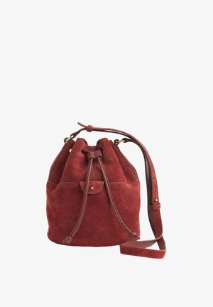 Sac seau en daim rouge avec fermeture à cordon, accents en cuir et bandoulière réglable. Comprend une petite poche avant et une texture douce.