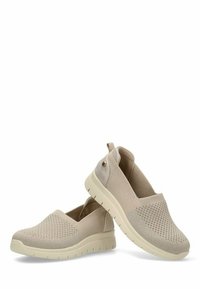 Zapatos beige tipo slip-on con parte superior de punto texturizado y una suela baja y acolchada. Sutiles acentos laterales y un bucle en la parte del talón.