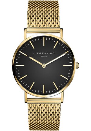 Montre ronde avec un bracelet en maille dorée, cadran noir, marqueurs d'heure dorés minimalistes et aiguilles. Nom de la marque "Liebeskind Berlin" affiché.