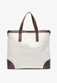 Canvas tote bag in white with brown leather accents. Features two sturdy handles and a reinforced base. Clean, minimalistic design.