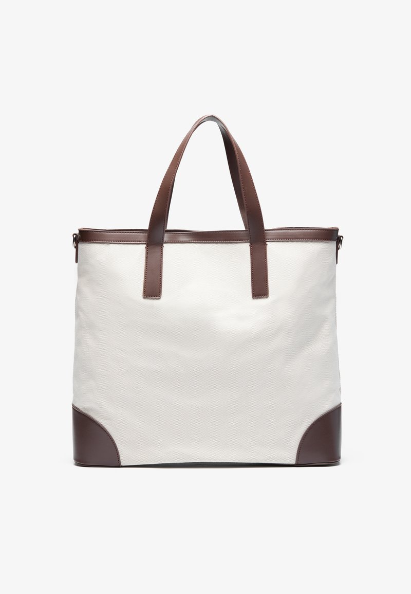 Canvas tote bag in white with brown leather accents. Features two sturdy handles and a reinforced base. Clean, minimalistic design.