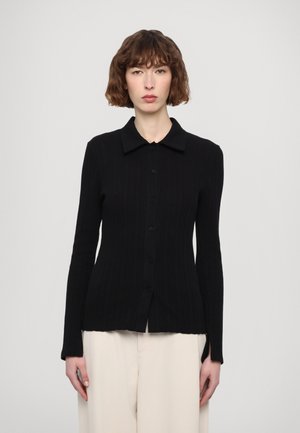 Cardigan negro de punto acanalado con mangas largas, cuello con solapa y botones frontales. Presenta una textura sutil y un dobladillo recto.