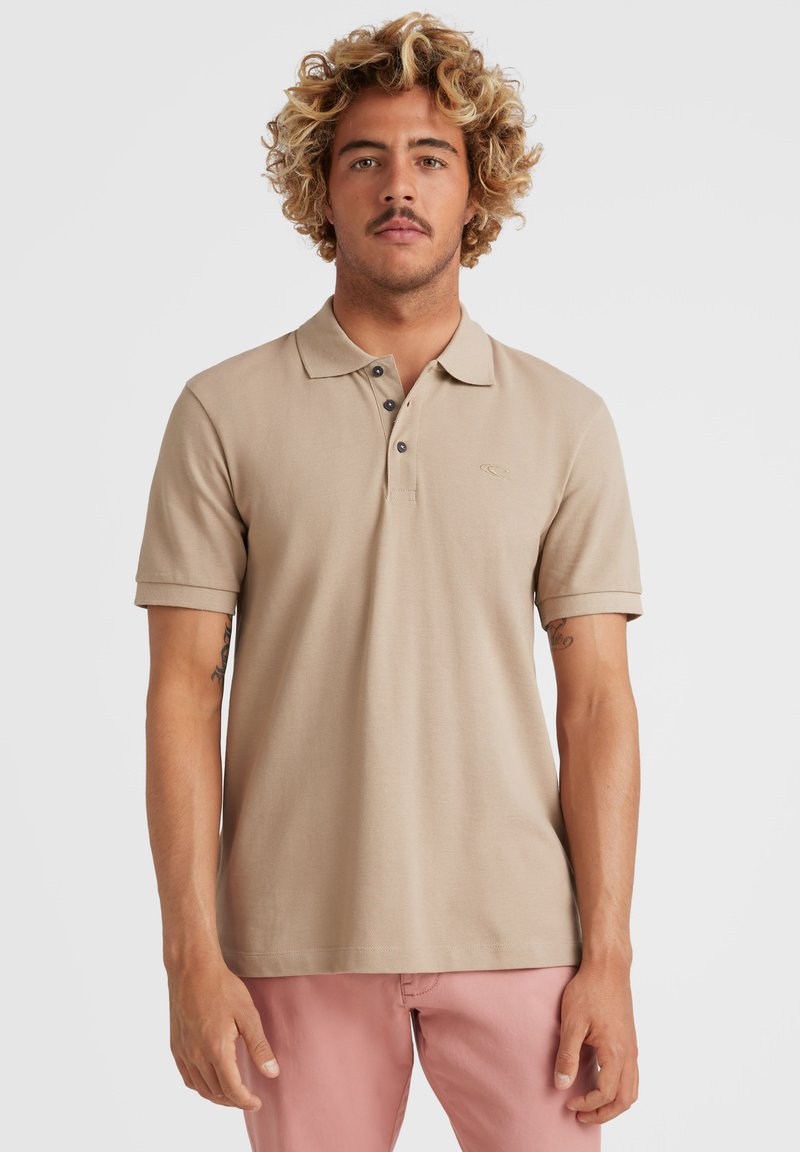 Beige polo t-shirt lavet af en bomuldsblanding, med krave, korte ærmer, tre-knaps placket og diskret logo broderi på brystet.