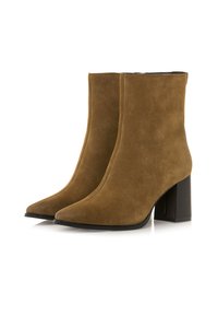 Ein Paar braune Wildleder-Stiefeletten mit spitzer Zehenform und Blockabsätzen auf einem weißen Hintergrund.