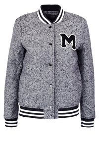 Grå mønstret varsityjakke med et sort "M" patch, trykknapper, ribbede manchetter og et stribet kravedesign. Blød tekstur.