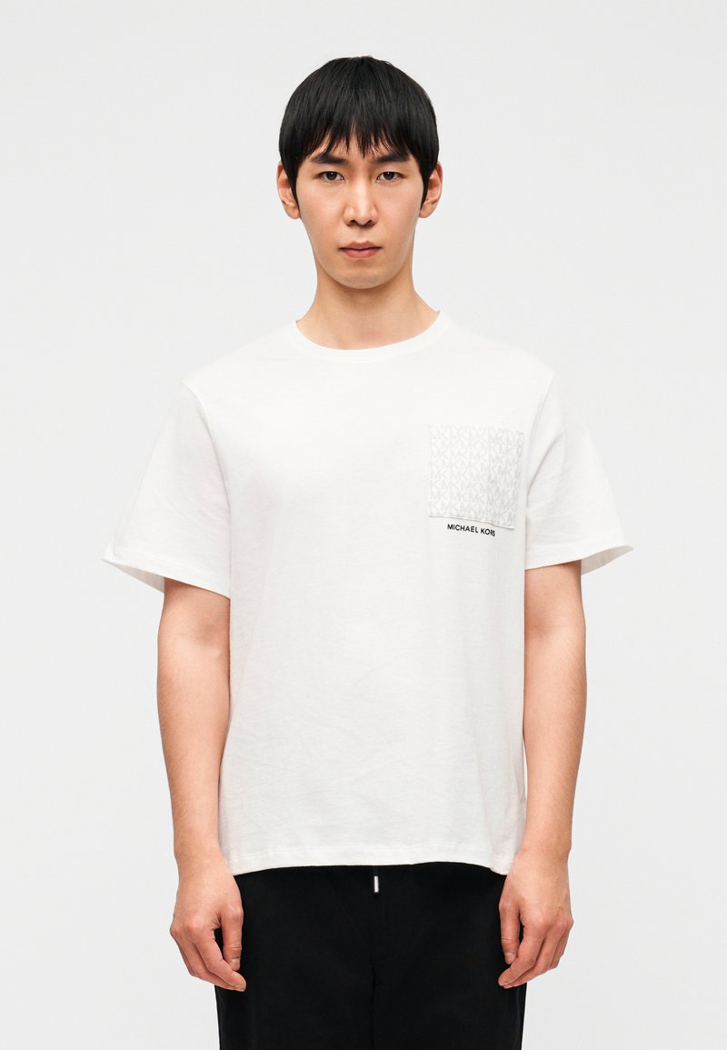 Λευκό βαμβακερό t-shirt με κοντά μανίκια, που διαθέτει τσεπάκι με μοτίβο και σήμα "MICHAEL KORS" κοντά στο τελείωμα.