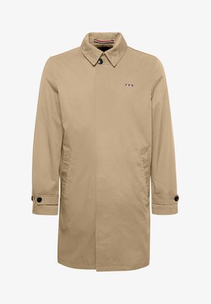 Beige színű trench coat, hegyes gallérral, egygombos záródással, oldalsó zsebekkel és fekete gomb díszítéssel. Kék, fehér és piros színű logóval rendelkezik.