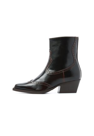 Brown leather ankle boot with a pointed toe, decorative brogue detailing, and a low stacked heel. Features a sleek and polished finish.