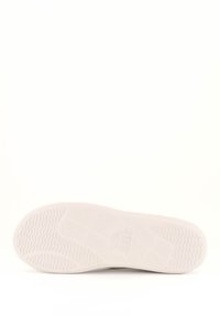 Weiße Gummisohle mit strukturiertem Muster und Logo-Detail. Glatte, flache Basis mit Rillen für Traktion und Stabilität.