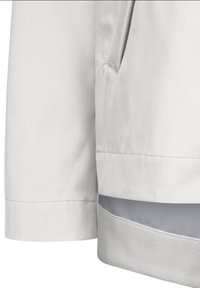 Helle graue Jacke mit glatter Textur, ausgestattet mit einer Seitentasche und einem geschichteten Saum mit kontrastierender Innenseite.