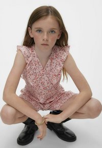 Vestido mini rosa con estampado floral y mangas rizadas, combinado con botas negras hasta el tobillo. Presenta una cintura fruncida y un accesorio de pulsera.