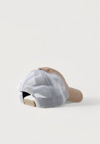 Καπέλο μπέιζμπολ με μπεζ εμπρόσθιο μέρος και λευκό πίσω μέρος από δίχτυ. Ο σχεδιασμός περιλαμβάνει ραφές ως διακοσμητικά στοιχεία και ρυθμιζόμενο λουράκι στο πίσω μέρος.