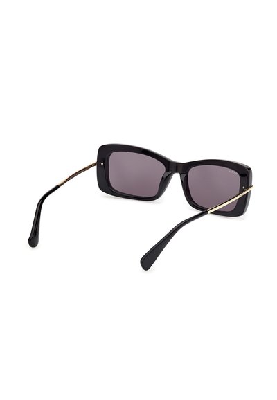 Lunettes de soleil rectangulaires noires avec des verres foncés et des branches fines en or, posées sur un fond blanc, vues de l'arrière.