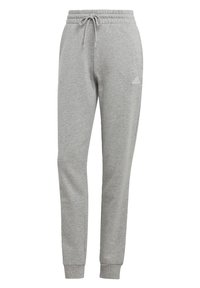 Graue Sweatpants aus weichem Material mit elastischem Bund, Kordelzug und Bündchen an den Knöcheln, mit einem kleinen weißen Adidas-Logo auf dem Oberschenkel.