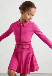 Ružičasta haljina od pletene tkanine, s ovratnikom, prednjim patentnim zatvaračem, dugim rukavima, plisiranom suknjom i ukrasnim gumbima na struku.