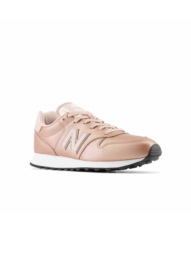Chaussure de sport en cuir rose avec surface texturée, bout rond, col rembourré et semelle intermédiaire blanche. Présente l'emblématique logo "N" en rose clair.