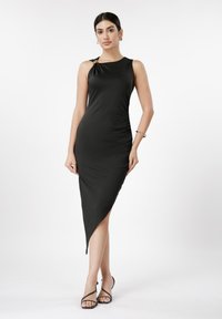 Čierne šaty bez rukávov z hladkej látky; majú uzlový detail na ramene a asymetrický lem. Elegantný a priliehavý dizajn.