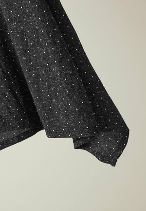 Tissu noir à motifs avec de petits pois blancs ; texture douce ; design drapé avec un ourlet arrondi et une silhouette décontractée.