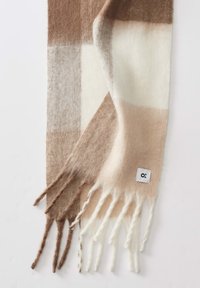 Sciarpa in lana con motivo a scacchi nei toni del marrone, beige e crema. Estremità frangiata con un piccolo tag logo bianco.
