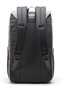 Mochila negra y gris vista desde atrás, con correas de hombro ajustables y acolchadas, un asa superior y un bolsillo con cremallera lateral.