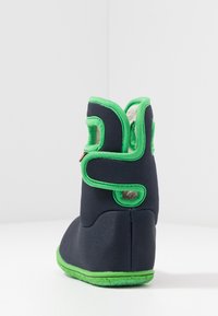 Morskie buty z tkaniny z zielonymi akcentami, teksturowaną podeszwą oraz regulowanymi paskami. Posiadają miękką podszewkę i wycięcia po bokach.