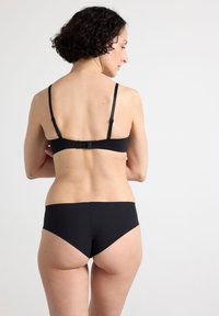 Mustast kaheosalisest bikiinidest komplekt, millel on lihtne disain ja tagaküljel lukk ülalt ning õmblusteta püksikud. Sile tekstuur.