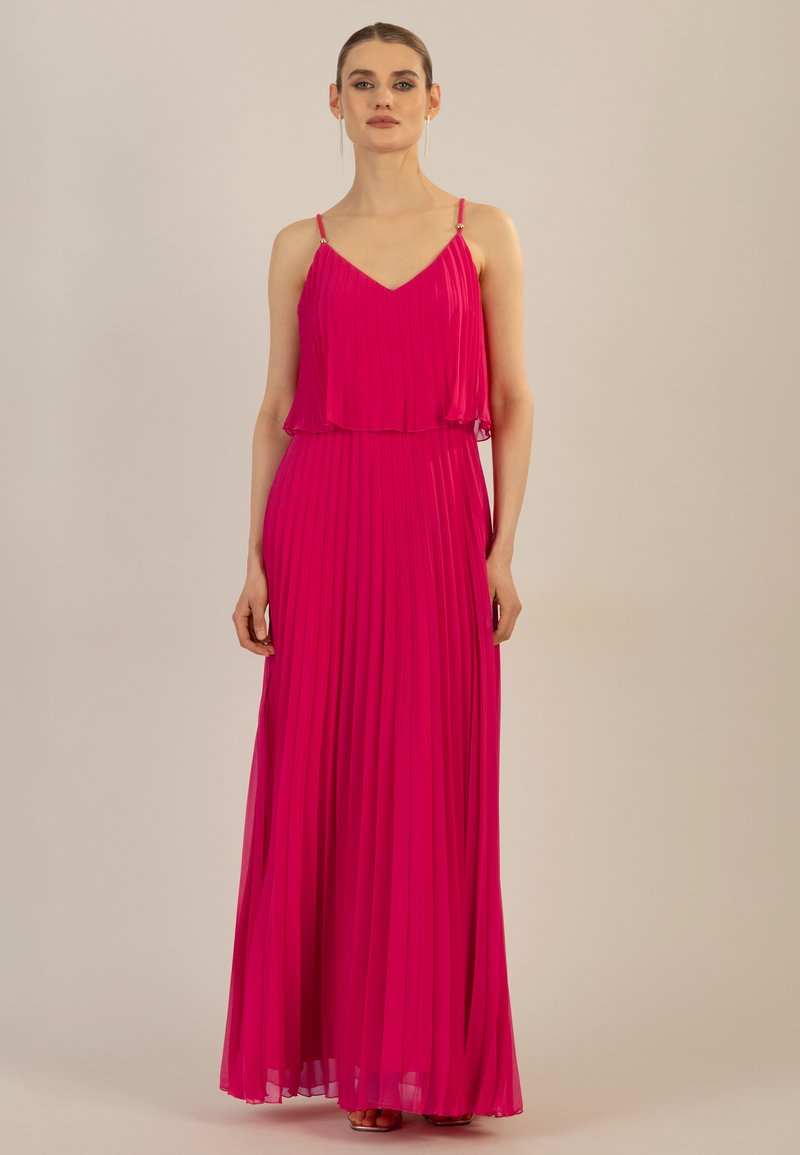 Falten Maxi-Kleid aus leuchtend rosa Stoff mit Spaghetti-Trägern und gestuftem Design. Verfügt über eine fließende Silhouette und eine glatte Textur.