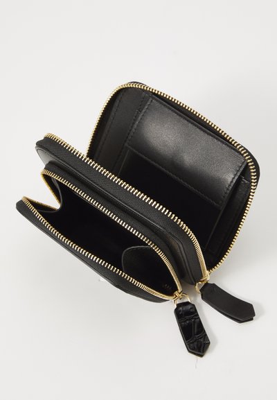 Portafoglio in pelle nera con chiusura a zip, dotato di hardware dorato, più slot per carte e accenti a contrasto all'interno. Design compatto e strutturato.