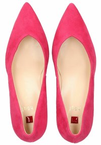 Růžové semišové boty na vysokém podpatku s špičatou špičkou a nízkým vystřižením na bocích, s hladkou béžovou vnitřní stélkou a malým červeným akcentem na patě.