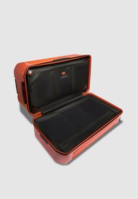 Hartschalenkoffer in Orange mit schwarzem Innenraum. Verfügt über mehrere Fächer, Reißverschlüsse und strukturierte Außenlinien für besseren Halt.