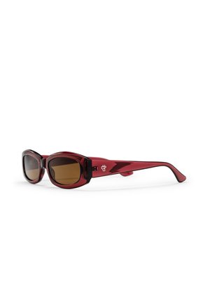 rot getönte Sonnenbrille mit übergroßen ovalen Gläsern. Die glänzenden Bügel sind mit einem Logo an der Schläfe versehen. Braune Gläser bieten UV-Schutz.