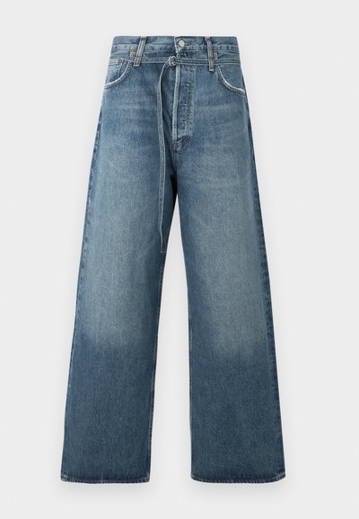 Wide-leg blue jeans in a faded wash, crafted from denim with visible stitching accents and a button fastening at the waist.