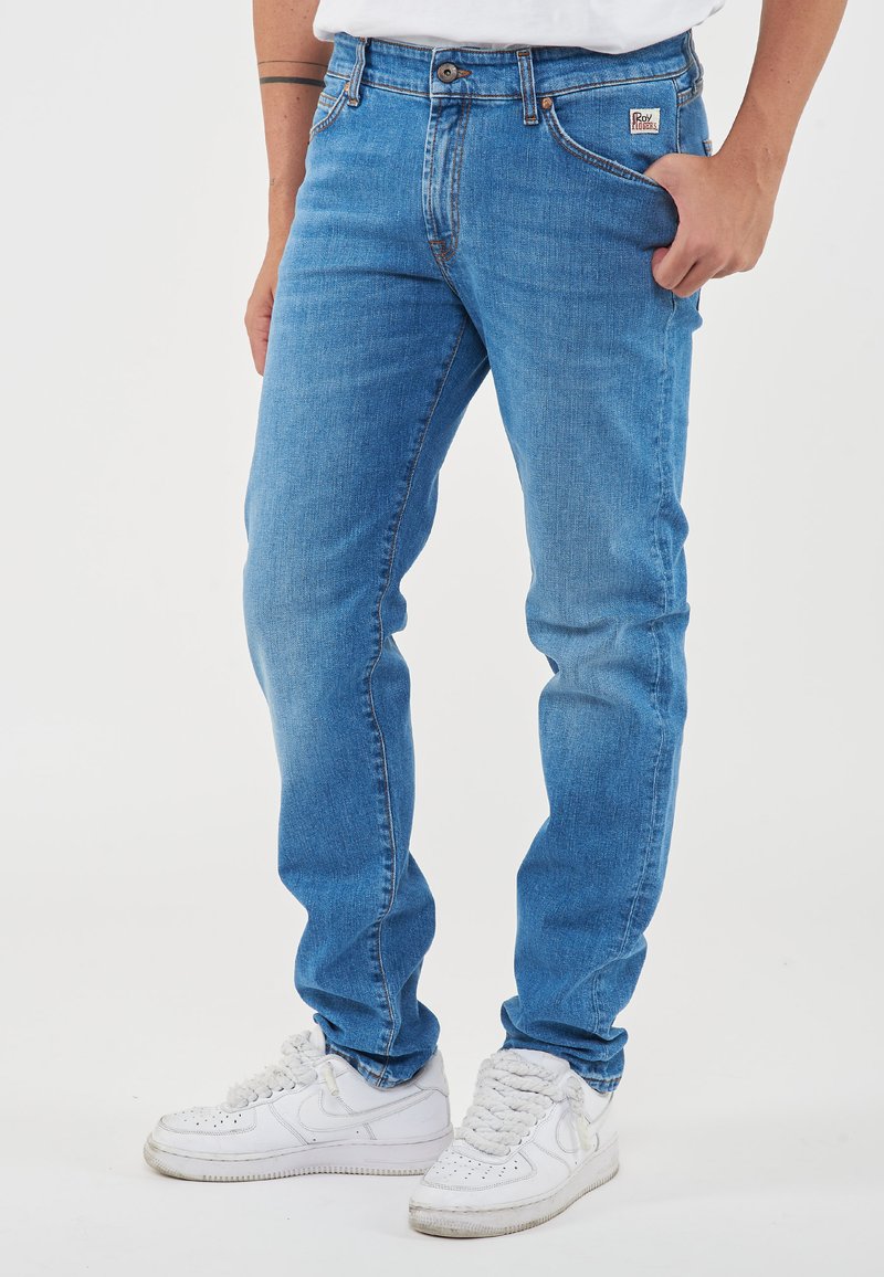 Jeans in denim azzurro chiaro con vestibilità slim, design a cinque tasche, cuciture a contrasto e un'etichetta del marchio sulla vita posteriore.
