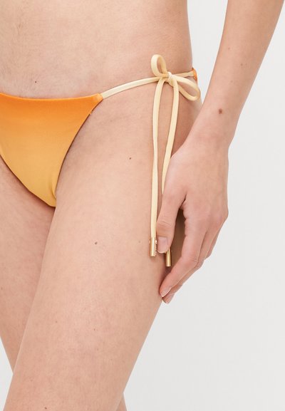 Orange satin bikini bottom with beige ties at the sides, featuring gold hardware accents and a smooth texture.