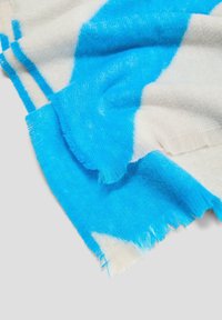 Zachte, franjen sjaal in lichtcrème met gedurfde blauwe abstracte patronen. Lichtgewicht textuur, geschikt voor laagjes of als accentstuk.