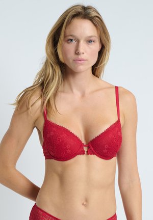 Czerwony koronkowy biustonosz w kwiatowy wzór z usztywnianymi miseczkami i regulowanymi ramiączkami. Posiada dekoracyjny otwór w kształcie klucza na środku. Gładka faktura.