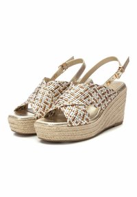 Sandalias de cuña con parte superior de tejido trenzado en tonos marrón y dorado, correa ajustable en el tobillo y tacón de plataforma envuelto en yute. Plantilla metálica suave.