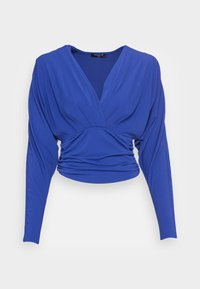Kungsblå långärmad topp med djup V-ringning och samlad detalj vid midjan. Tillverkad av mjukt, stretchigt tyg.