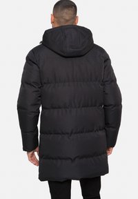 Černá péřová bunda s kapucí, kterou zdobí prošívaný design a boční kapsy. Materiál vypadá hladce a má střední délku.