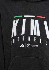 Felpa nera con cappuccio caratterizzata da testo bianco audace. Presenta accenti verdi, bianchi e rossi. Mostra i loghi di Adidas e Mercedes. Tessuto di superficie liscia.