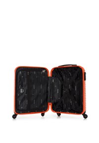 Valise rigide de couleur orange vif, avec un extérieur texturé, un intérieur noir à motif rayé et des sangles croisées pour maintenir le contenu.