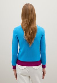 Maglione blu con maniche lunghe, dalla forma aderente e una cintura a costine bordeaux. Texture lavorata a maglia; la vista posteriore mostra una finitura liscia.