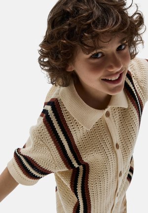 Cardigan en tricot crème avec un motif texturé, doté d'un col, d'une fermeture à boutons et de rayures diagonales en rouge, noir et marron.